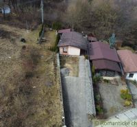 The exterior of the cottage in Kvakovce with the surrounding nature and a paved yard.