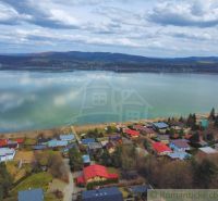 Cottage by the lake in Kvakovce with a panoramic view of the water surface and the sky.