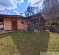 A cottage in Kvakovce with a lawn and a gazebo, bordered by trees and a forest backdrop.