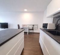 A kitchen in a 2-room apartment with a wooden decor floor and modern equipment.