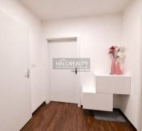 Entrance hallway in a 2-room apartment with wood-patterned flooring and white furniture.