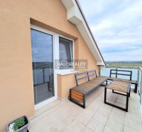 A balcony with wooden furniture in a two-room apartment with a view of nature in Pezinok.