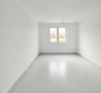 A spacious bright room with a window in a 2-room apartment, white tiles.