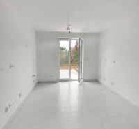 A spacious room with large windows and white walls in a 2-room apartment.
