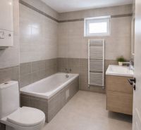 Bathroom in a 2-room apartment with a bathtub, sink, and tiled floor.