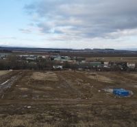 Development plots in Mlynica with expansive countryside and partly cloudy skies.