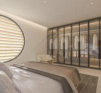 A bedroom in a villa with a large window, a wardrobe with glass doors, and a bed.
