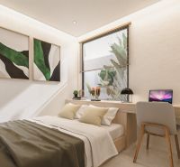 Bedroom in a villa with a bed, wall decorations, and a desk.