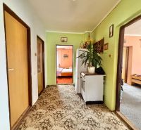 A hallway with carpeted flooring in a family house with entrances to rooms.