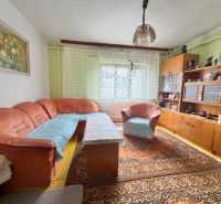 Living room of a family house with an orange sofa and wooden furniture.