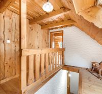Wooden staircase and wooden paneling in a family house with a swing.