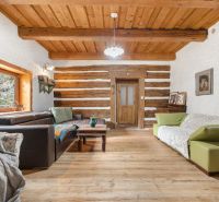 Living room in a family house with sofas, wooden beams, and a floor with a wooden decor.