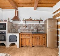 Interior of a family house with a kitchenette, oven, wooden furniture, and a floor with a wooden decor.