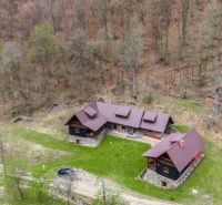 An aerial view of a family house in Horná Mariková, surrounded by an autumn forest.