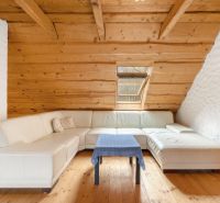 White corner sofa with a coffee table on a wooden-decor floor, family house.