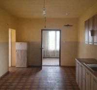 A kitchen in a family house with a wooden decor floor and a simple countertop.