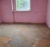 A room in a family house with pink walls and a wooden decor floor.