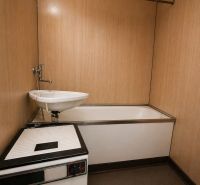 A bathroom with a bathtub and a sink in a 2-room apartment.