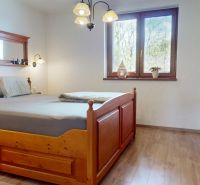 A bedroom in a family house with wooden furniture and a wooden decor floor.