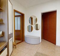 Entrance hall in a family house with tiles, decorative shelves, and mirrors.