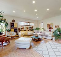 A spacious living room in a family house with plants and comfortable furniture.