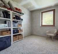 Storage space with shelves, racks, and a comfortable armchair in a family house.