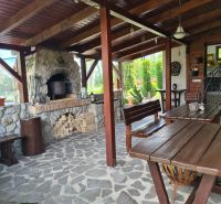 Covered terrace in Šamorín with a garden fireplace and wooden furniture by a 3-room apartment.