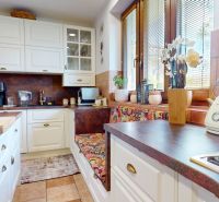 A kitchen in a family house with white cabinets and a cozy window.