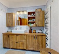 Bathroom in a family house with wooden decor furniture, a sink, and a mirror.