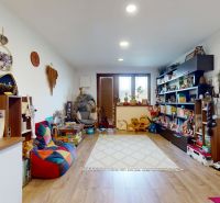 A room in a family house with toys and books, a floor with a wooden decor.