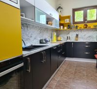 A kitchen in a 3-room apartment with a marble decor and yellow accents.