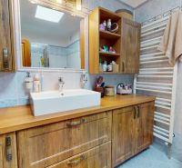 A bathroom with wooden decor and cabinets in a family house, elegant storage spaces.