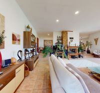 Living room of a family house with a fireplace, light furniture, and decorations.