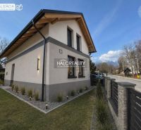 A family house in Nová Lesná with wooden cladding and a stone facade, mountain view.