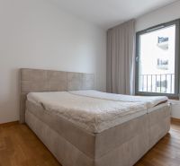 Bedroom in a 3-room apartment with a bed and a wooden decor floor.