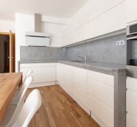 A kitchen in a 3-room apartment with a wood-decor floor and built-in appliances.
