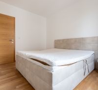 A bedroom with a bed on the floor with wooden decor in a 3-room apartment.