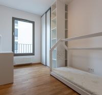 Children's room in a 3-room apartment with a bed and white furniture on a wooden decor floor.