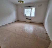 An empty room with parquet flooring and a window in a family house, basic design without furniture.