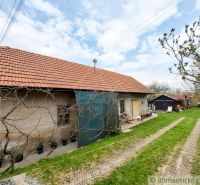 A family house in Stožok with a red tiled roof and greenery in the yard.