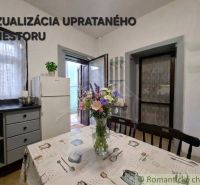 Dining room in a family house with flowers on the table and a white refrigerator.