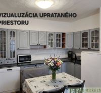A kitchen in a family house with gray cabinets and flowers on the table.