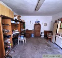 Interior of a cabin with shelves, a cabinet, and a chair, suitable for storing items.