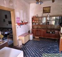 A cottage kitchen with retro furniture, tiles, and decorative elements.