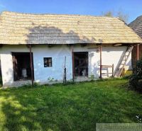 A cottage in Šahy with a thatched roof and a landscaped garden.