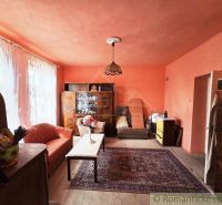 The interior of a family house with orange walls, carpet, and vintage furniture.