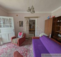 Living room in a family house with carpeted floor and retro furniture.