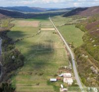 A valley with fields and forests, a road leading to a family house in Zubné.