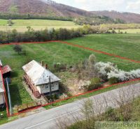 A family house in Zubné with a spacious plot, bordered by a road and trees.