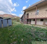 A family house in Zubné with a grassy yard and a view of the hills.